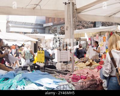 Cremona, Italie 31 août 2024 clients naviguant et achetant des vêtements dans une variété d'étals dans un marché en plein air dans le centre-ville Banque D'Images