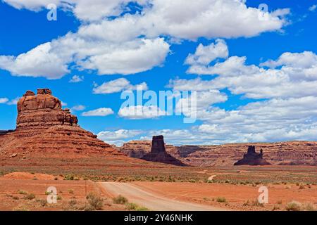 Le chemin de terre serpente à travers la vallée parsemée d'arbustes parmi Putterman dans la baignoire, Castle, de Gaulle et ses troupes Buttes à la Vallée des dieux de l'Utah Banque D'Images