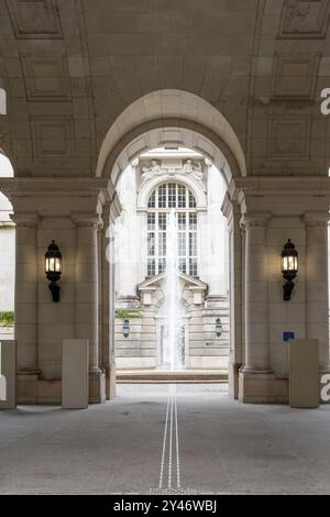 Une grande arche avec une fontaine au milieu. L'arche est en pierre et la fontaine est blanche Banque D'Images