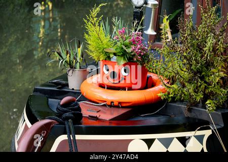 Aspirateur Henry utilisé comme conteneur de plantes sur un bateau étroit, Royaume-Uni Banque D'Images