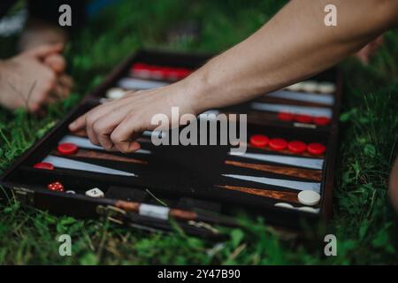 Jeu de backgammon en plein air avec des amis sur un terrain herbeux Banque D'Images