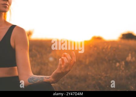 Femme Yogi en Lotus pose méditant au coucher du soleil Banque D'Images