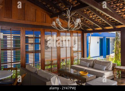 Hôtel Pousada Porto Imperial. Paraty, Brésil. Style colonial. Bar et salon à côté de la piscine. Décor rustique, canapés en bois et bois de cerf. Banque D'Images