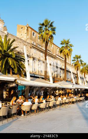 Les gens dînent al fresco dans les restaurants le long de la promenade de Riva au bord de l'eau, Split, Croatie Banque D'Images