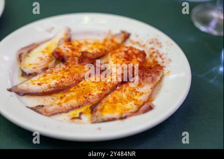 Plat andalou traditionnel fruits de mer poulpe servi avec paprika pimento rouge dans une ancienne taverne comme tapa, Sanlucar de Barrameda, Espagne Banque D'Images