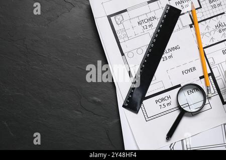 Différents dessins architecturaux, crayon, règle et loupe sur table texturée grise, pose à plat. Espace pour le texte Banque D'Images
