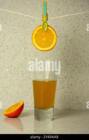 Soleil fraîchement pressé dans chaque goutte. La confection d'un verre de jus d'orange. Banque D'Images