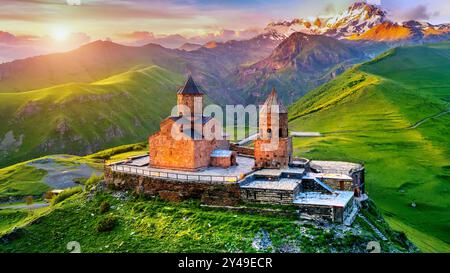 Vue aérienne de l'église de la trinité de Gergeti au lever du soleil en Géorgie. Banque D'Images