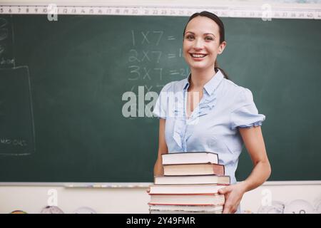 Cours de mathématiques, professeur heureux et livres pour la connaissance, l'apprentissage et la résolution de problèmes pour le développement. Femme, portrait et salle de classe pour la solution Banque D'Images