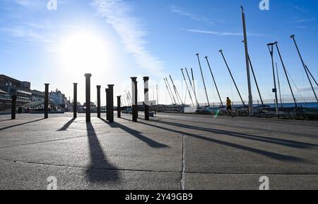 Brighton UK 17th septembre 2024 - les coureurs et les marcheurs profitent du soleil tôt le matin près des piliers Golden Spiral sur le front de mer de Brighton comme un temps plus chaud et ensoleillé est prévu pour le reste de la semaine dans certaines parties du Royaume-Uni . Les vingt-quatre colonnes en fonte de la Golden Spiral faisaient à l'origine partie de la substructure de la jetée ouest : crédit Simon Dack / Alamy Live News Banque D'Images