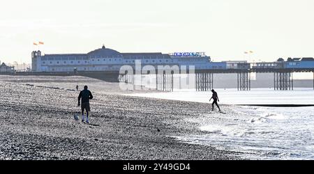 Brighton UK 17 septembre 2024 - les marcheurs tôt le matin et les nageurs apprécient le soleil d'automne sur la plage de Brighton comme un temps plus chaud et ensoleillé est prévu pour le reste de la semaine dans certaines parties du Royaume-Uni : crédit Simon Dack / Alamy Live News Banque D'Images