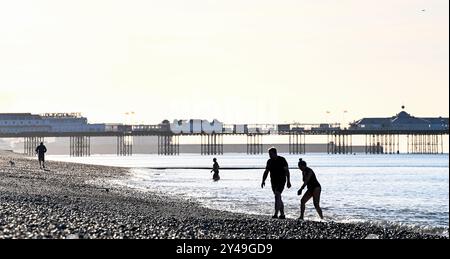 Brighton Royaume-Uni 17 septembre 2024 - les nageurs et les marcheurs en mer tôt le matin apprécient le soleil d'automne sur la plage de Brighton car un temps plus chaud et ensoleillé est prévu pour le reste de la semaine dans certaines parties du Royaume-Uni : crédit Simon Dack / Alamy Live News Banque D'Images