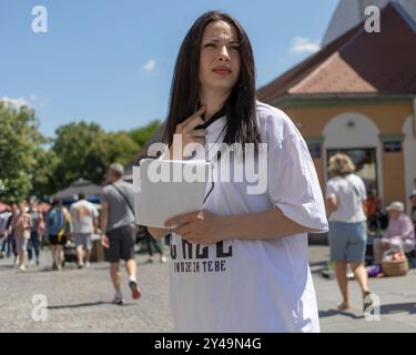 Serbie, 18 mai 2024 : une jeune femme distribue des tracts dans la rue dans le cadre d’une campagne politique pour les élections municipales à Belgrade. Banque D'Images