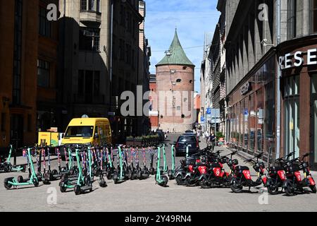 Riga, Lettonie- 23 juillet 2024 : scooters électriques et bus de livraison DHL dans la rue de Riga. Banque D'Images