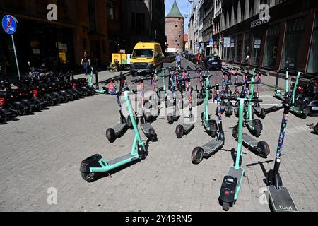 Riga, Lettonie- 23 juillet 2024 : scooters électriques et bus de livraison DHL dans la rue de Riga. Banque D'Images