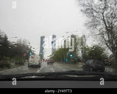 Une photo d'une fenêtre éclaboussée de pluie, révélant un arrière-plan de voiture traficc. Vue des gouttes de pluie sur la fenêtre Banque D'Images