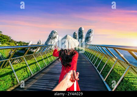 Femmes touriste tenant la main de l'homme et le conduisant au Golden Bridge à Da nang, Vietnam. Banque D'Images