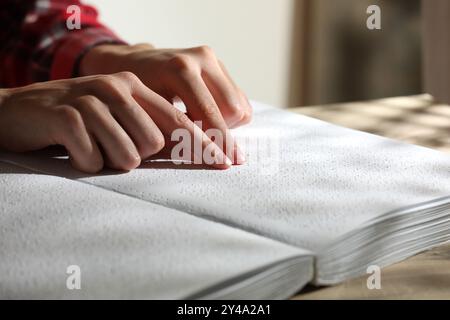 Femme aveugle lisant un livre écrit en braille à table, gros plan Banque D'Images