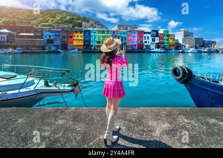 Touriste prenant une photo au port de pêche coloré de Zhengbin à Keelung, Taiwan. Banque D'Images