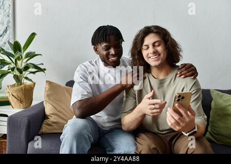 Un couple aimant partage le rire en regardant leur téléphone dans leur maison confortable. Banque D'Images