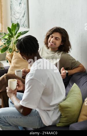 Un moment joyeux se déroule comme un couple aimant profite de boissons chaudes ensemble dans leur espace confortable. Banque D'Images