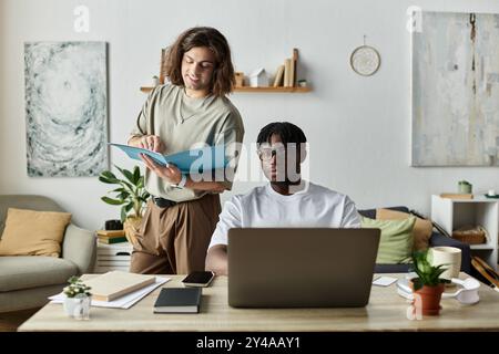 Deux partenaires s'engagent dans le travail et la conversation, créant une atmosphère chaleureuse et aimante à la maison. Banque D'Images