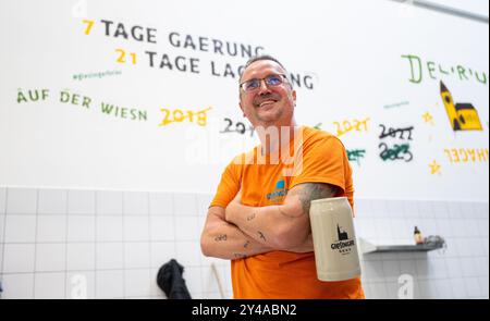 PRODUCTION - 17 septembre 2024, Bavière, Munich : le fondateur et directeur général de Giesinger Biermanufaktur, Steffen Marx, se tient devant un mur de la brasserie sur lequel sont rayées les années où la brasserie n'était pas représentée à l'Oktoberfest. Pendant des décennies, il n'y avait que six brasseries munichoises originales, mais Giesinger Bräu les a récemment rejointes en tant que septième bière - et veut maintenant assister à l'Oktoberfest. Photo : Lukas Barth/dpa Banque D'Images