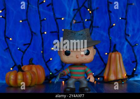 Funko Pop figurine de Freddy Krueger de la franchise d'horreur Nightmare sur Elm Street. Brouillard bleu, toile d'araignée, lumières colorées, citrouilles d'Halloween. Banque D'Images