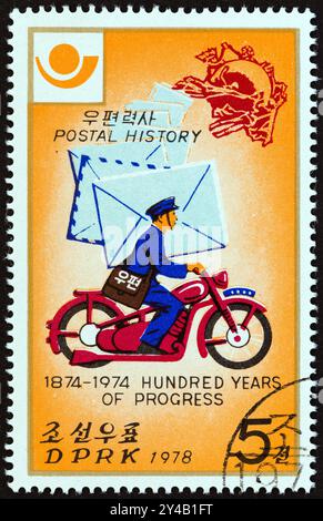 CORÉE DU NORD - VERS 1978 : un timbre imprimé en Corée du Nord à partir de l'émission "postal Progress" montre Postman à moto Banque D'Images