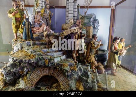 Scène de la crèche décorée avec art avec des figurines dans des vêtements traditionnels, des animaux et un paysage luxuriant Banque D'Images