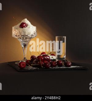 Ingrédients pour les boulettes ukrainiennes : farine dans un bol en verre, cerises et eau. Banque D'Images