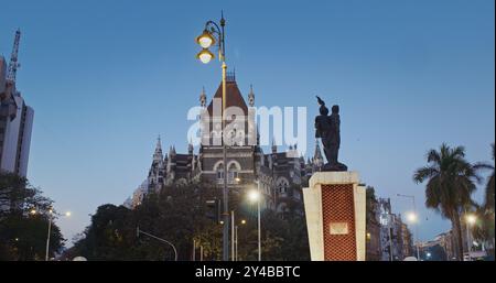 Mumbai, Inde. Les gens marchent jettent Hutatma Chowk ou Martyrs Square. Square accueille la fontaine de fleurs. Statue de Martyr avec flamme se dresse à côté de Flora Banque D'Images