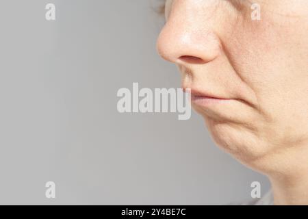 Gros plan du visage inférieur de la femme mature montrant la texture naturelle de la peau et les signes de vieillissement Banque D'Images