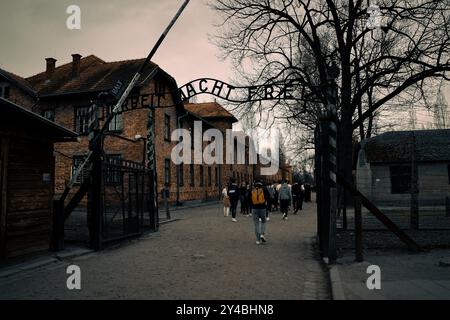 Une vue sombre des visiteurs entrant dans le camp de concentration d'Auschwitz, un mémorial des atrocités de l'Holocauste. Banque D'Images