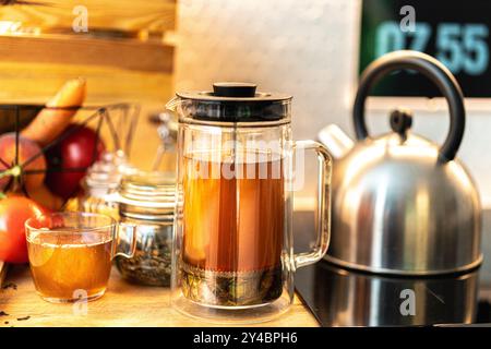 bouilloire à thé avec piston. Table intérieure de cuisine. Pots d'épices, préparation de boisson chaude. Banque D'Images