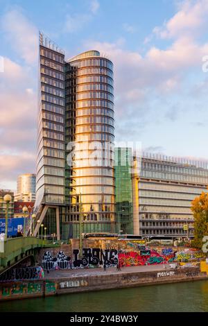 vienne, autriche - 17 octobre 2019 : remblai de donaukanal en automne. belle architecture de tour uniqua et arbres en saison d'automne au coucher du soleil. scène urbaine Banque D'Images