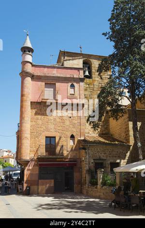 Bâtiment historique avec tour d'église et café attenant avec terrasse sous un arbre par une journée ensoleillée, Iglesia de San Estaban, Plasencia, Caceres, Caceres Banque D'Images