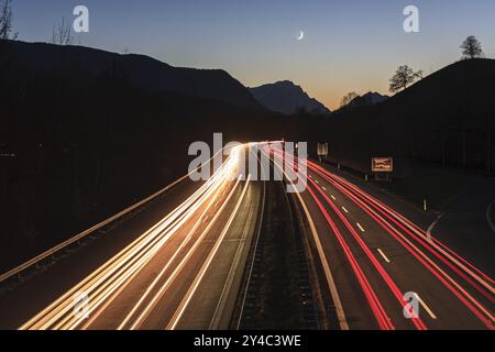 Photo de nuit d'une autoroute, longue exposition, lune, crépuscule, trafic, feux de voiture, A 95, derrière elle Zugspitze, Bavière, Allemagne, Europe Banque D'Images