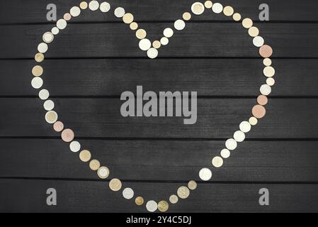 Pièces dispersées de différents pays sous la forme d'un point d'interrogation et d'un point d'exclamation sur la table en bois Banque D'Images