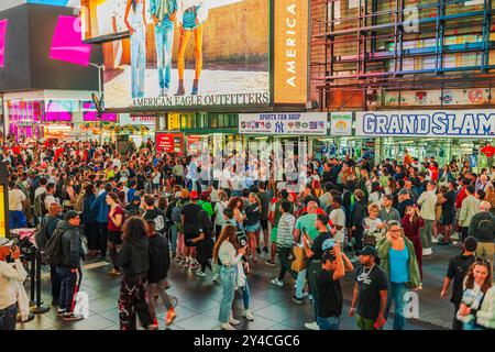 Belle vue de la grande foule réunie à Times Square, New York City, entouré de publicités lumineuses et d'activités animées au cœur de la ville. Nouveau Banque D'Images
