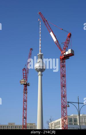 La célèbre tour de télévision de Berlin avec deux grues de construction rouges Banque D'Images