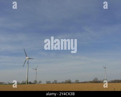 Éoliennes sur un champ doré sous un ciel bleu, wuellen, muensterland, detuschland Banque D'Images