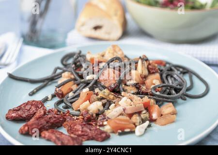 Spaghetti al Nero di seppia avec fruits de mer et tomates Banque D'Images