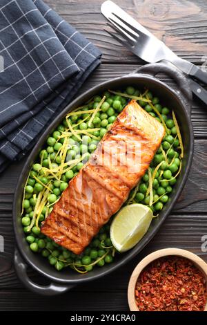 Délicieux filet de saumon grillé dans un plat de cuisson servi sur une table en bois, plat Banque D'Images