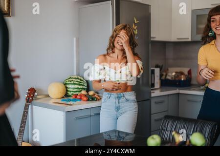 Jeunes femmes jouissant du rire dans un décor de cuisine moderne Banque D'Images