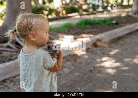 Portrait d'adorable jeune fille blonde jouant et embrassant des chatons errants Banque D'Images