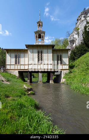 Le bâtiment bien formé, construit sur un plan en forme de croix et bordé de planches lumineuses, est soutenu par des pilotis enracinés dans le lit d'un ruisseau Banque D'Images