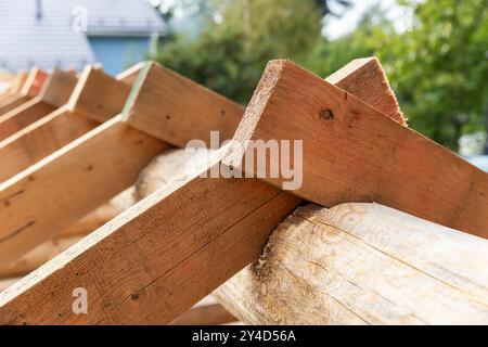 Chevrons et bûche à poutres faîtières. Photo d'arrière-plan avec flou sélectif. Toit de maison en bois est en construction Banque D'Images