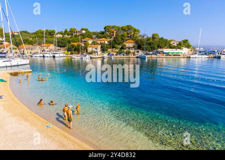 Les gens nagent sur une plage dans le village de Rogac, Solta, Côte Adriatique, Croatie Banque D'Images