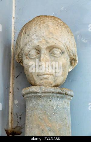 Une tête en marbre altérée sur une colonne dans la cour de Sant'Agata dei Goti, une ancienne église de Rione Monti à Rome, en Italie Banque D'Images